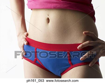 Stock Image - Woman in pink T shirt and blue briefs, close-up. Fotosearch