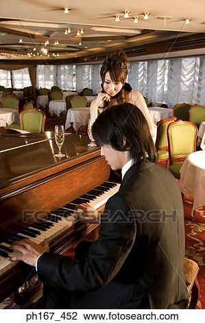 Woman looking at man playing piano View Large Photo Image Stock Image - Woman looking at man playing piano. Fotosearch
