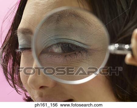 Woman looking through a magnifying glass, close-up View Large Photo Image Stock Photograph - Woman looking through a magnifying glass, close-up. Fotosearch