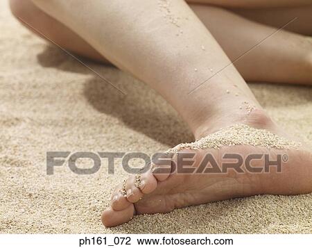 Stock Image - Woman lying on beach. Fotosearch