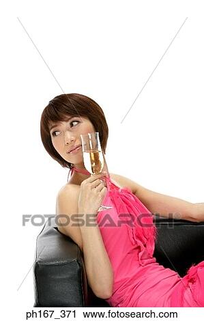 Woman relaxing on a sofa with a glass of champagne View Large Photo Image Stock Image - Woman relaxing on a sofa with a glass of champagne. Fotosearch