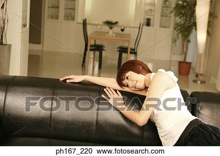Woman resting her head on sofa headrest View Large Photo Image Stock Image - Woman resting her head on sofa headrest. Fotosearch