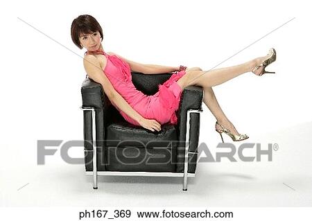 Woman sitting on a sofa View Large Photo Image Stock Photo - Woman sitting on a sofa. Fotosearch