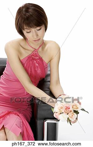 Woman sitting on a sofa with a bouquet of roses View Large Photo Image Stock Image - Woman sitting on a sofa with a bouquet of roses. Fotosearch