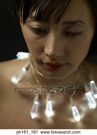 Stock Photo - Woman wearing lights as necklace. Fotosearch