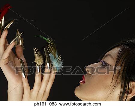 Woman with a fang and feathers on finger nails, side profile View Large Photo Image Stock Image - Woman with a fang and feathers on finger nails, side profile. Fotosearch