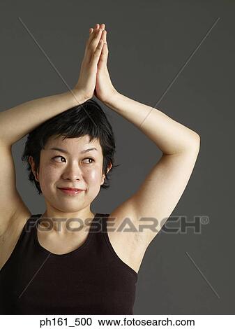 Woman with clasped hands above head View Large Photo Image Stock Image - Woman with clasped hands above head. Fotosearch