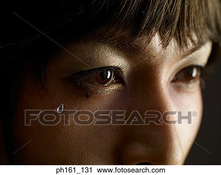 Stock Image - Woman with crystal tear, close-up. Fotosearch