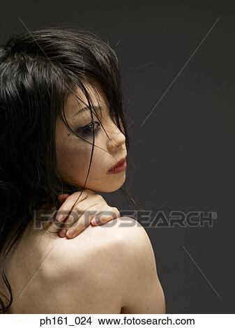 Woman with hand on shoulder, looking back View Large Photo Image Picture - Woman with hand on shoulder, looking back. Fotosearch