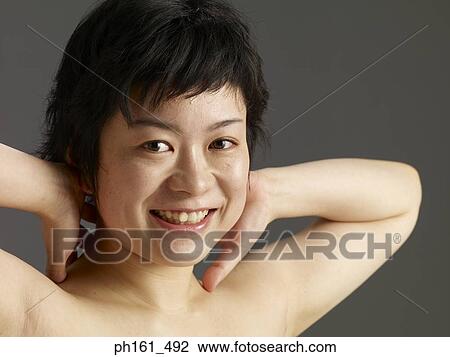 Stock Image - Woman with her hands at back of head. Fotosearch