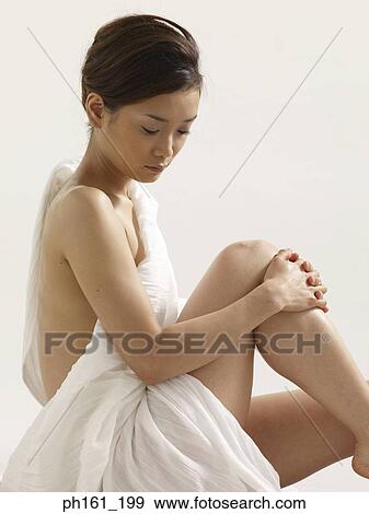 Woman wrapped in white cloth, sitting down and holding her knee, side view View Large Photo Image Stock Photo - Woman wrapped in white cloth, sitting down and holding her knee, side view. Fotosearch
