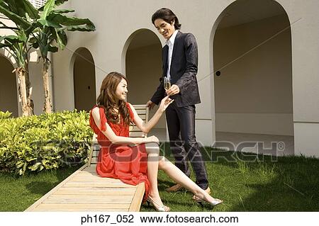 Young couple relaxing in the courtyard, with champagne View Large Photo Image Stock Image - Young couple relaxing in the courtyard, with champagne. Fotosearch