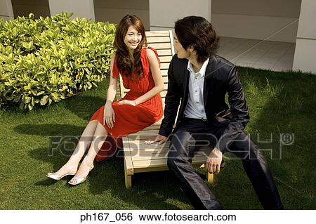 Young couple sitting on deck chair, relaxing, high angle View Large Photo Image Stock Photograph - Young couple sitting on deck chair, relaxing, high angle. Fotosearch