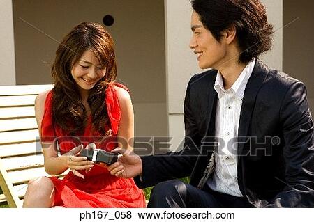 Stock Photo - Young man giving woman a present. Fotosearch