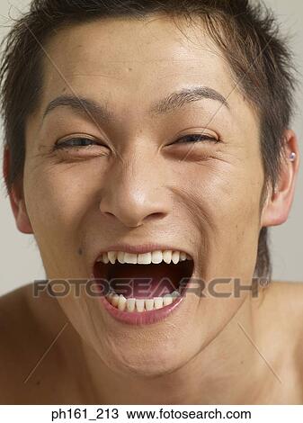 Young man laughing with mouth open wide, close-up View Large Photo Image Stock Image - Young man laughing with mouth open wide, close-up. Fotosearch