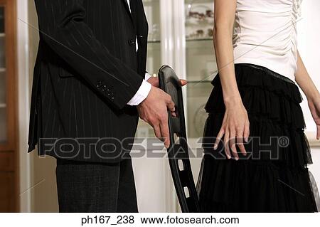Young man pulling a chair out for woman, close-up View Large Photo Image Stock Photo - Young man pulling a chair out for woman, close-up. Fotosearch