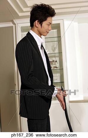 Stock Photograph - Young man pulling a chair out. Fotosearch