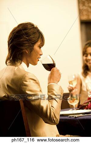 Stock Photograph - Young man with others holding a wine glass. Fotosearch