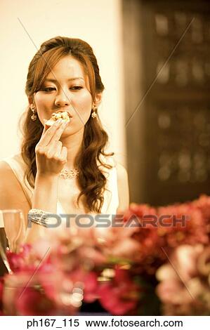 Young woman biting into food View Large Photo Image Stock Photography - Young woman biting into food. Fotosearch