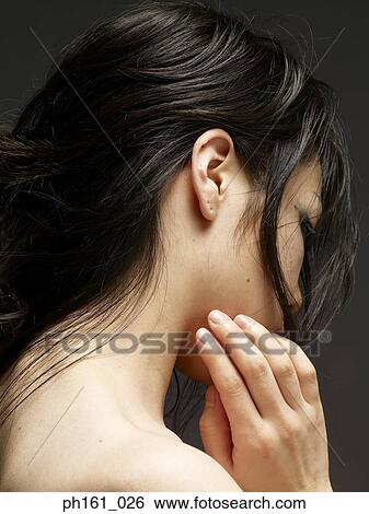 Stock Photograph - Young woman touching her face. Fotosearch