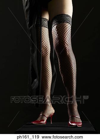 Young woman wearing mesh stockings and red heels, low section View Large Photo Image Stock Photo - Young woman wearing mesh stockings and red heels, low section. Fotosearch
