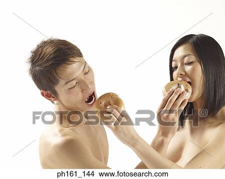 Youth couple feeding each other bagels View Large Photo Image Picture - Youth couple feeding each other bagels. Fotosearch