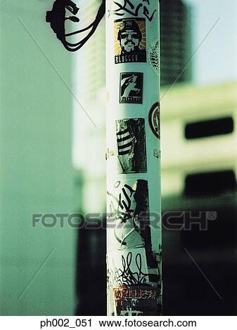 Stock Image - Graffiti and stickers on lamp post. Fotosearch