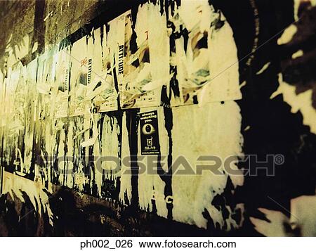 Stock Photograph - Graffiti and torn posters on wall. Fotosearch
