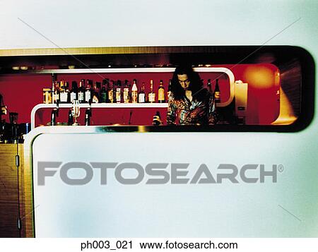 Stock Image - Bartender behind a bar counter. Fotosearch