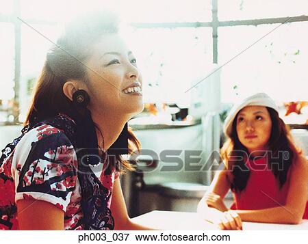 Two Asian women at a café View Large Photo Image Stock Photo - Two Asian women at a café. Fotosearch