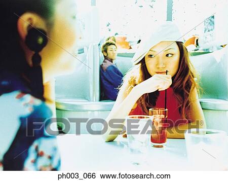 Two Asian women at a café View Large Photo Image Stock Photograph - Two Asian women at a café. Fotosearch
