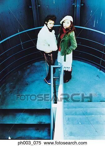 Two women standing at stairs landing View Large Photo Image Stock Photography - Two women standing at stairs landing. Fotosearch