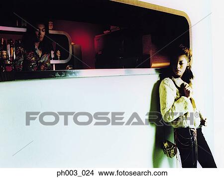 Picture - Woman standing at a bar counter. Fotosearch