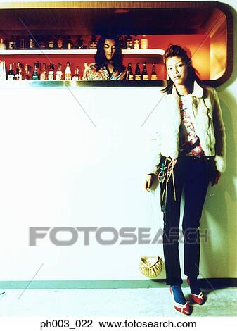 Woman standing at a bar counter View Large Photo Image Stock Image - Woman standing at a bar counter. Fotosearch