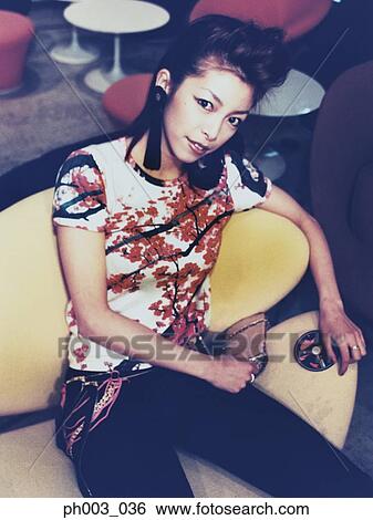 Stock Photograph - Young Asian woman at a café. Fotosearch