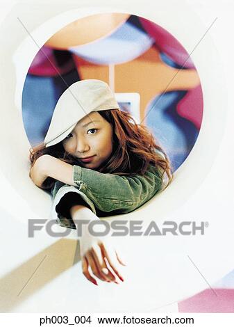 Picture - Young Asian woman, round shape window. Fotosearch