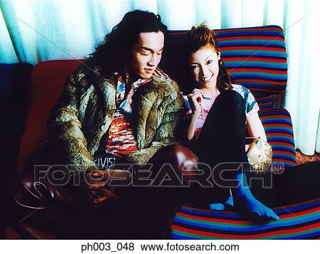 Young couple on a sofa, smiling View Large Photo Image Stock Photo - Young couple on a sofa, smiling . Fotosearch