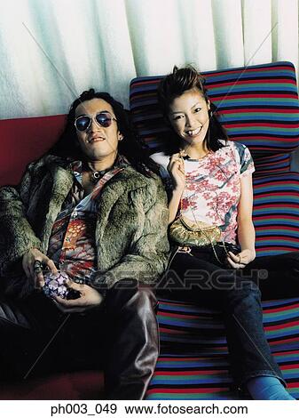 Young couple on a sofa, smiling View Large Photo Image Stock Photo - Young couple on a sofa, smiling . Fotosearch