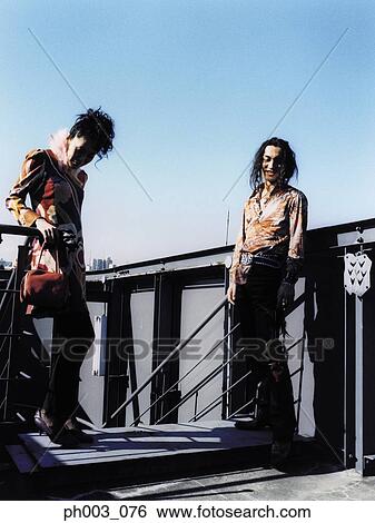 Stock Photograph - Young couple standing at rooftop. Fotosearch