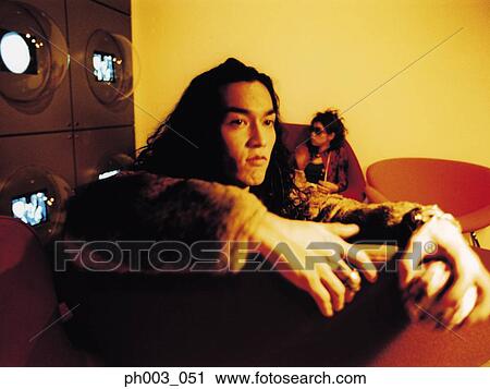 Young man sitting on a sofa, hand holding ball, close-up View Large Photo Image Stock Image - Young man sitting on a sofa, hand holding ball, close-up . Fotosearch