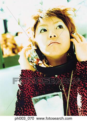 Stock Image - Young woman listening to headphones, portrait, close up. Fotosearch