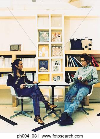 Two young men reading books and magazines View Large Photo Image Stock Image - Two young men reading books and magazines. Fotosearch