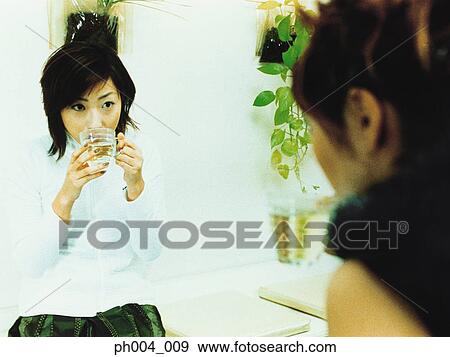 Stock Photo - Two young woman chatting and drinking. Fotosearch