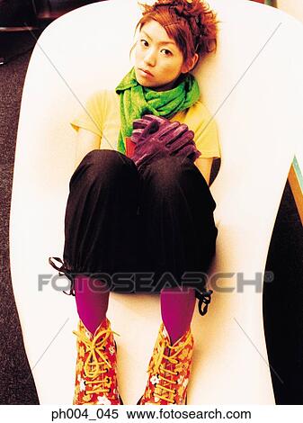 Stock Photography - Woman lying on curved chair. Fotosearch