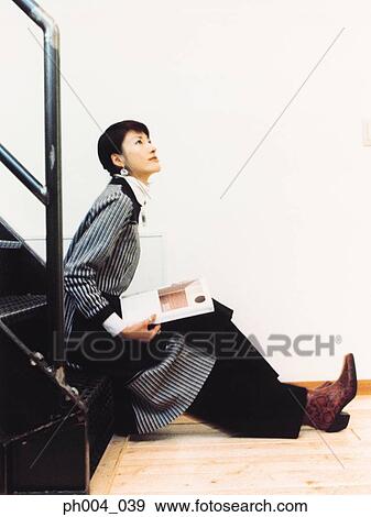 Woman sitting on steps with a book View Large Photo Image Stock Photo - Woman sitting on steps with a book. Fotosearch