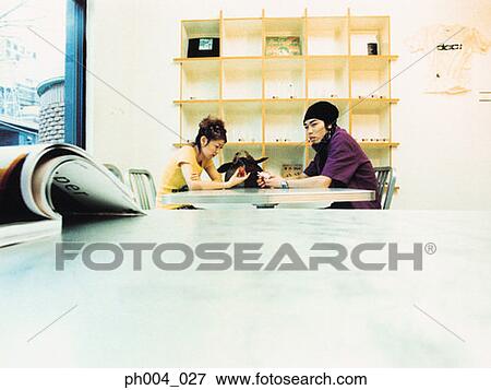 Stock Photo - Young couple sitting at table. Fotosearch