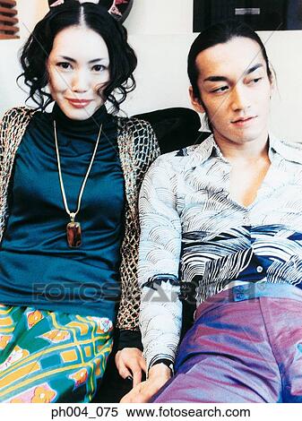Stock Photography - Young couple sitting on a sofa, portrait. Fotosearch