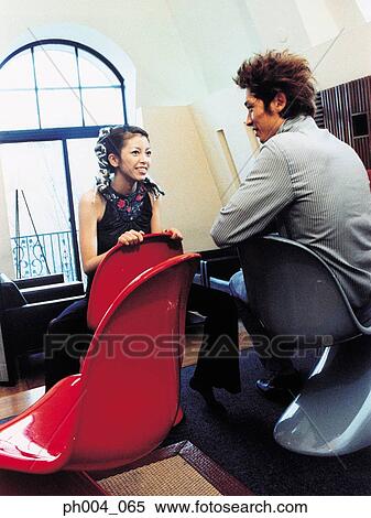 Young man and woman sitting across from each other, talking View Large Photo Image Stock Photography - Young man and woman sitting across from each other, talking . Fotosearch