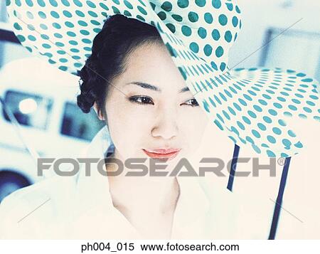Stock Photography - Young woman wearing polka dotted hat, close-up . Fotosearch