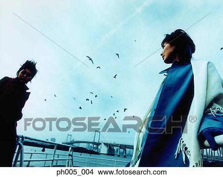 Two Woman with Tokyo city in background, a flock of seagulls View Large Photo Image Picture - Two Woman with Tokyo city in background, a flock of seagulls. Fotosearch
